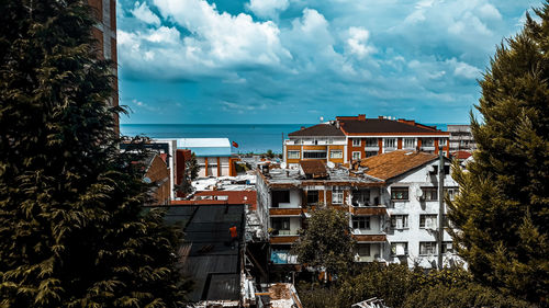 High angle view of buildings and sea against sky