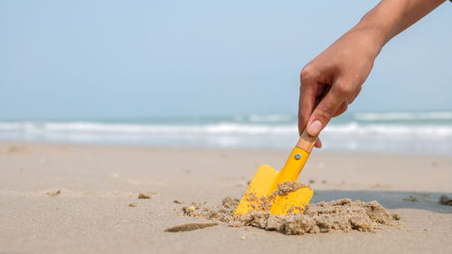 The hand of a woman digging sand playing on the beach on a holiday