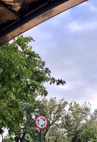 Low angle view of road sign against trees