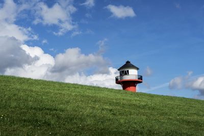 Low angle view of lighthouse on field against sky