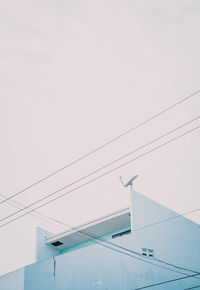 Low angle view of cables against sky in city