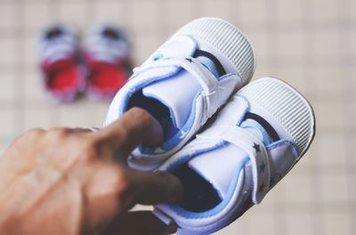 Close-up of person holding baby booties