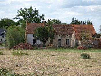 Abandoned house on field against sky