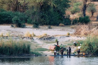 People on river by trees