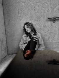 Portrait of young woman sitting on wall