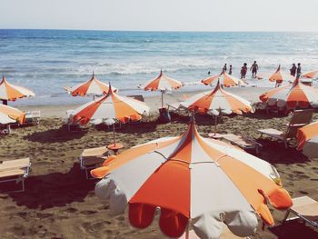 Canopies on beach against clear sky