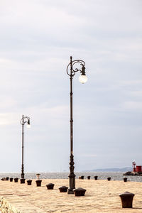 Street light against cloudy sky