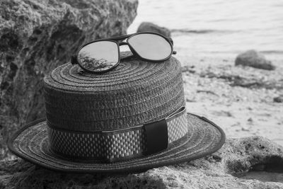 Close-up of hat on rock at beach