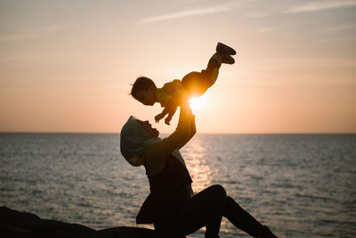 Silhouette man against sea during sunset