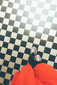 Low section of man standing on tiled floor