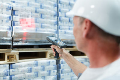 Rear view of man using scanner in industry warehouse 