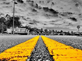 Surface level of road against cloudy sky