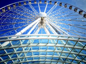 Low angle view of ferris wheel against blue sky