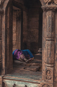 Woman sleeping in corridor of building