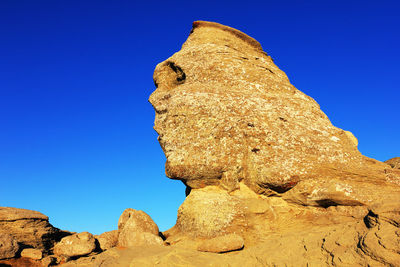 Sphinx rock formation against clear blue sky at bucegi natural park