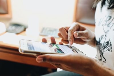 Close-up of man using mobile phone at home