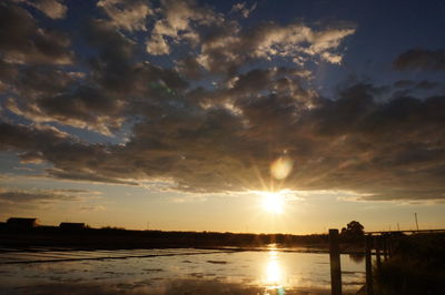 Sun shining through clouds over sea