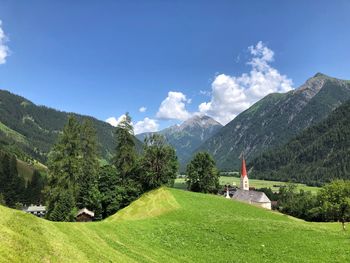 Scenic view of landscape and mountains against blue sky