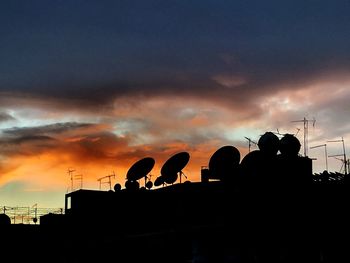 Silhouette of people against cloudy sky during sunset