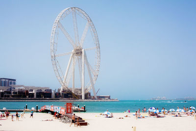 People on beach against clear sky