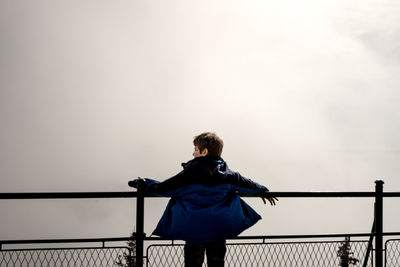 Low angle view of woman standing against sky