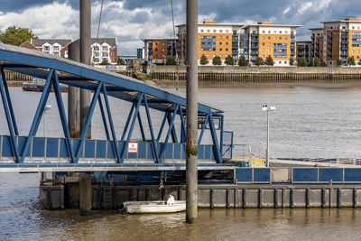 Bridge over river in city against sky