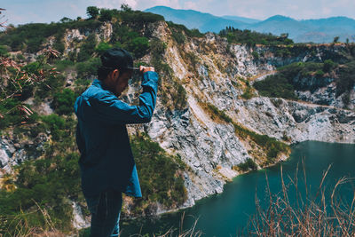 Man looking at sea against mountains