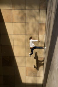 Man jumping against tiled floor