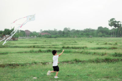 Rear view of boy standing on field