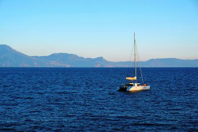 Sailboat sailing on sea against clear sky