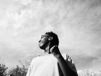 Portrait of young man looking away against sky