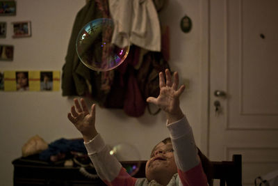 Girl playing with bubble in home