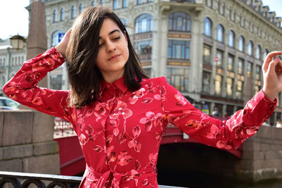 Woman standing by canal in city