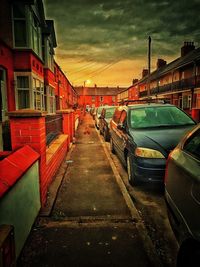 Road in city against sky during sunset