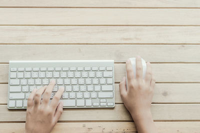 Directly above shot of person hands using computer mouse and keyboard