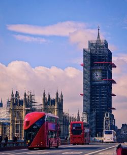 View of tower in city against cloudy sky