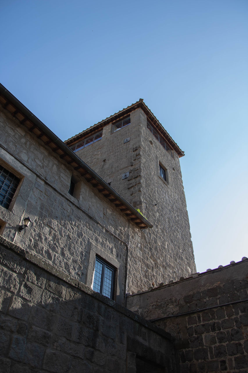 LOW ANGLE VIEW OF OLD BUILDING AGAINST CLEAR BLUE SKY