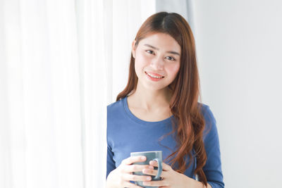 Portrait of young woman drinking coffee