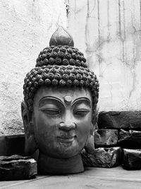 Close-up of buddha statue against wall