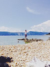 Rear view of woman sitting on beach