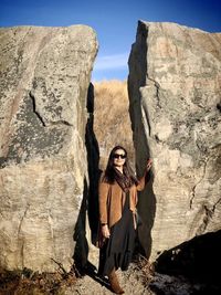 Portrait of young woman standing on rock