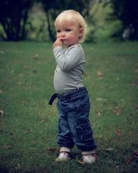 Full length of cute baby girl standing on grassy field