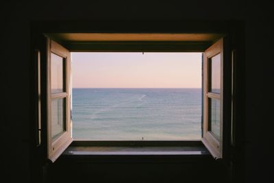 Scenic view of sea during sunset seen from window