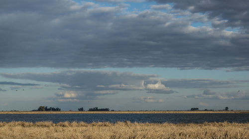 Scenic view of field against cloudy sky