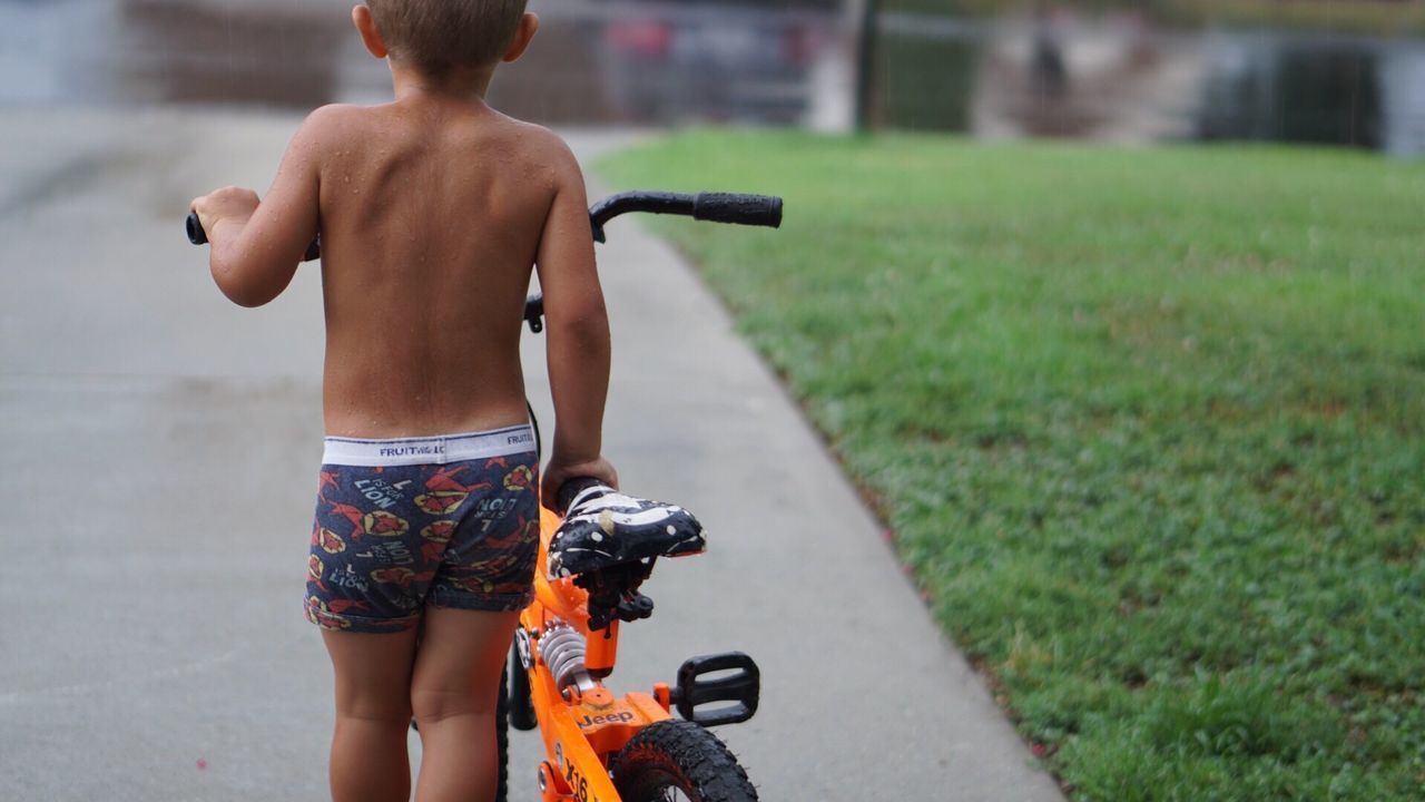 FULL LENGTH REAR VIEW OF SHIRTLESS MAN IN MID-AIR