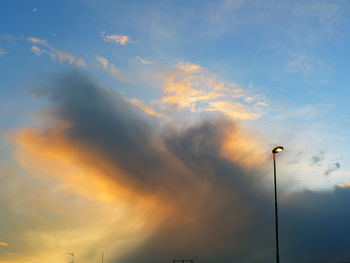 Low angle view of street lights against sky during sunset