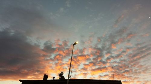 Low angle view of silhouette street light against sky at sunset