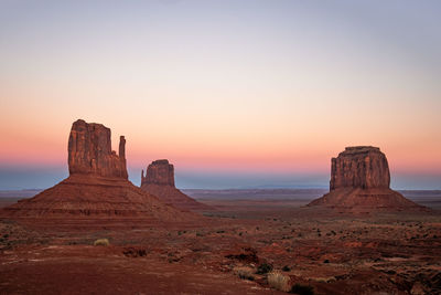 Rock formations on landscape against clear sky during sunset