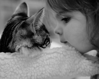 Close-up of girl with cat on bed