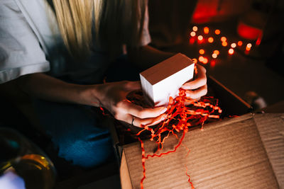 High angle view of woman holding christmas lights on table